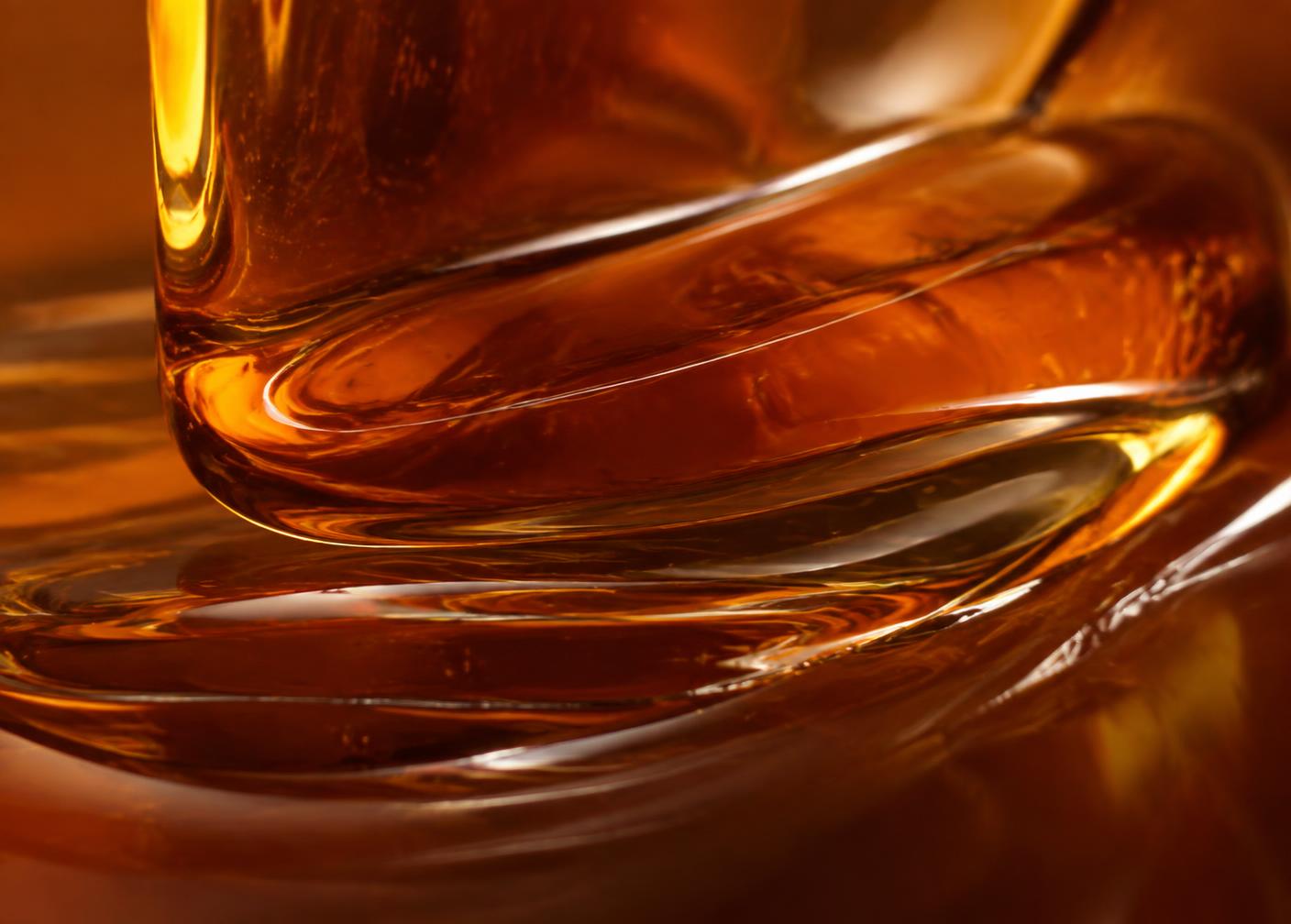 Close view of deep amber honey folding on itself